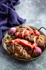 Roasted sliced pork with tomato sauce on vintage serving platter