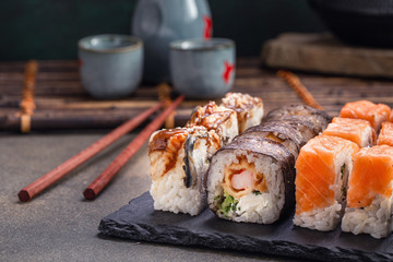 Sushi roll with salmon and shrimp closeup in dark ambience