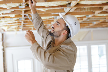male builder working on ceiling joists