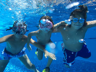 Obraz na płótnie Canvas Kids enjoying in pool underwater