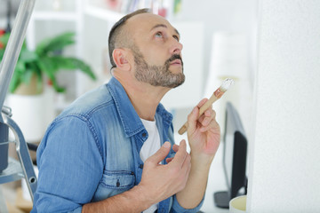 man painting a wall with a painbrush © auremar