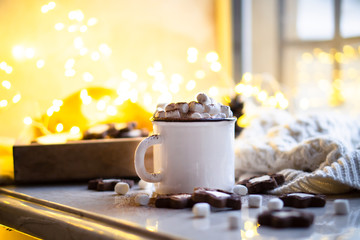 Comforting Christmas food, mug of hot cocoa with marshmallow and cookies with cozy lights
