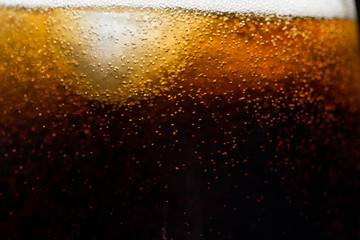 ice cubes on the background of cola, close-up. Black background