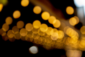 Abstract bokeh made from Christmas lights in the shop on black background. Holiday concept, overlay for your images.