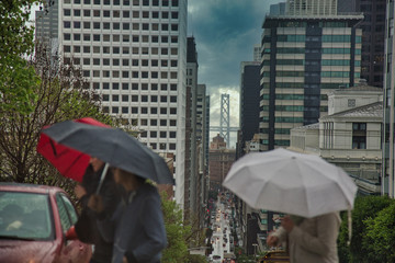People walking in San Francisco with umbrellas 
