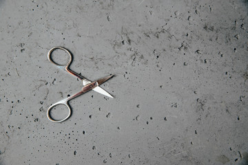 Scissors for cutting nails on a dark stone background. The concept of taking care of appearance....