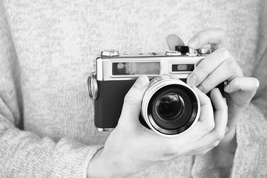 girl holding a camera and takes a picture, black and white, slide stilization