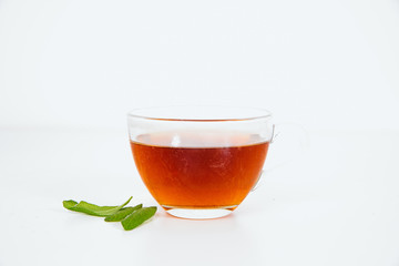 Sage and brewed sage in a cup on a white background. The concept of using herbs and spices at home.