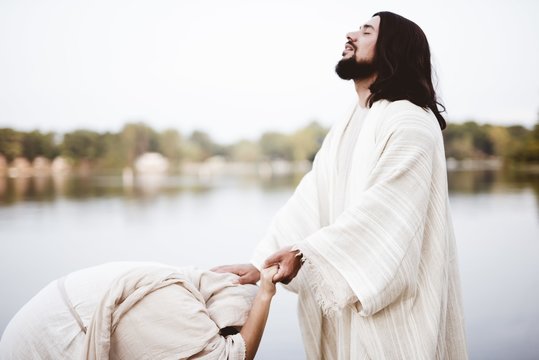 Shallow Focus Shot Of Jesus Christ Healing A Female With His Hand On Her Head