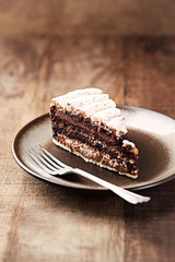 Piece of chocolate cake on rustic background.