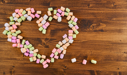 marshmallow heart, which means love, on a wooden background. Valentine's day. top view, free space on the right.