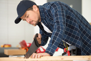 man sawing wood saw