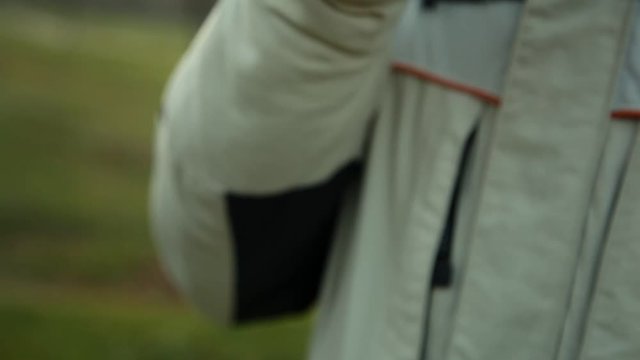 Hand with device of vaping young man in the park in the evening