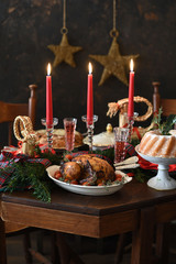  Baked turkey or chicken. The Christmas table is served with a turkey, decorated with fruits, salad and nuts. Fried chicken, table. Christmas dinner.