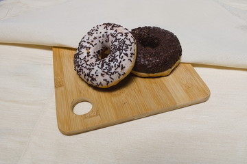 Donuts with black and white icing lie on a blackboard on a napkin