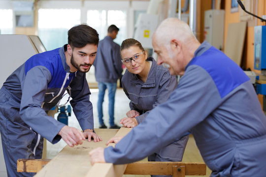 carpentry apprentice demonstrating machine operation