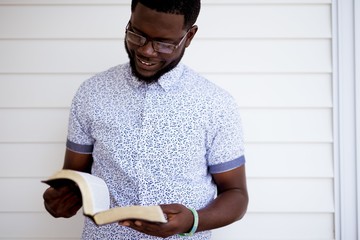 Shallow focus shot of a male holding and reading the bible