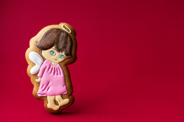 gingerbread cookie of little cute angels on red background. Traditional Christmas food. Christmas and New Year holiday concept.