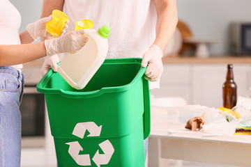 Couple with container for garbage at home. Concept of recycling