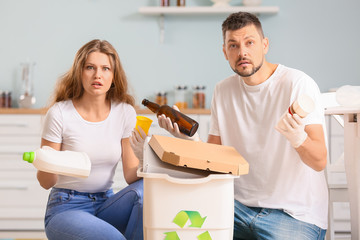 Couple sorting garbage at home. Concept of recycling