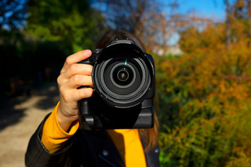Fototapeta premium Woman photographer showing closely her black reflex camera.