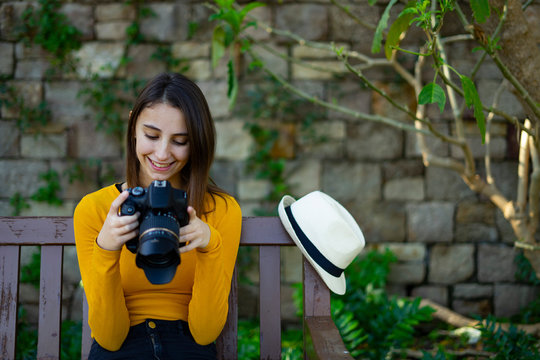 Photographer woman looking and reviewing her photos on the reflex camera.