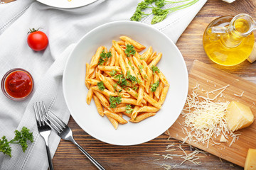 Plate with tasty pasta on wooden table