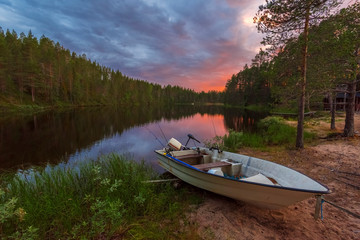 Evening Fishing In the border of Ala-Juumajarvi lake in Oulanka National Park, the sky in sunset colors is at background. Ostrobothnia, Finland.