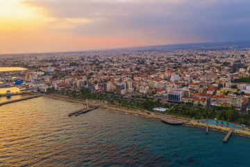 Obraz premium Aerial panoramic view of Molos Promenade park with alley at sunset on coast of Limassol, Cyprus. Famous mediterranean resort.