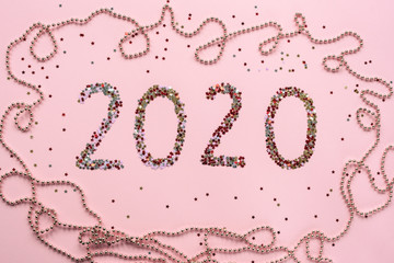 Numbers 2020 made of confetti on pink background. Christmas or New Year layout, flat lay, top view.