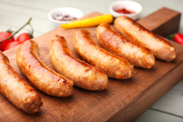 Tasty grilled sausages wooden board, closeup