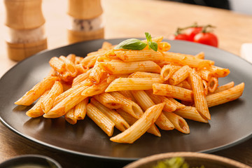 Tasty pasta with tomato sauce on plate, closeup