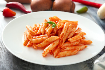 Plate with tasty pasta on wooden table