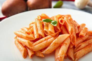 Tasty pasta with tomato sauce on plate, closeup