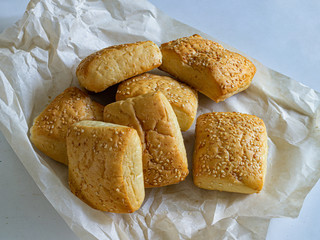 Milanese buns sprinkled with sesame seeds on a light background