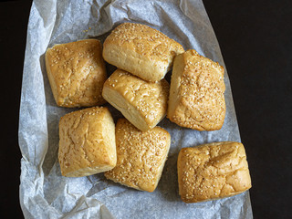 On a sheet of food parchment are Golden Milanese buns with sesame seeds