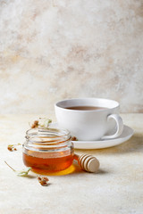 Obraz na płótnie Canvas Cup of of tea with honey and teapot