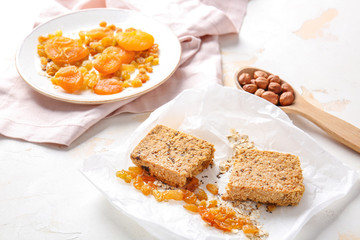 Tasty granola bar with ingredients on white background
