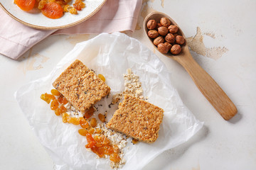 Tasty granola bar with ingredients on white background