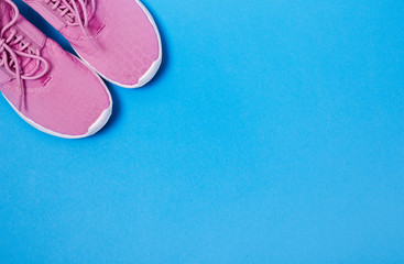 Pink sport shoes on a blue background. Concept healthy lifestyle, sport and diet. 