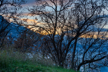 rural landscape, sunset in the mountains with snowy peaks, winter day