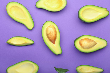 Ripe cut avocados on color background