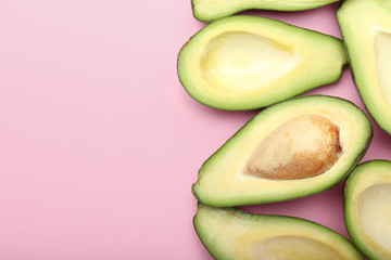 Ripe cut avocados on color background