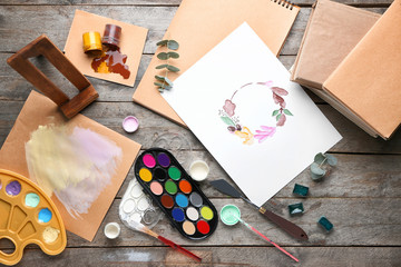 Set of artist's supplies on wooden background