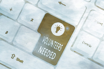 Conceptual hand writing showing Volunteers Needed. Concept meaning need work or help for organization without being paid White pc keyboard with note paper above the white background