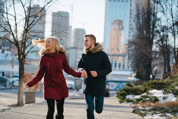 Happy couple walking in the street in winter in a town