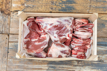 Fresh and raw sheep or lamb meat pieces for sale on box from the farm . on wooden background