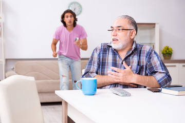 Young student and his old grandpa at home