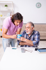 Young student and his old grandpa at home