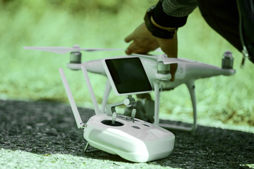 Man with remote control prepare white drone.